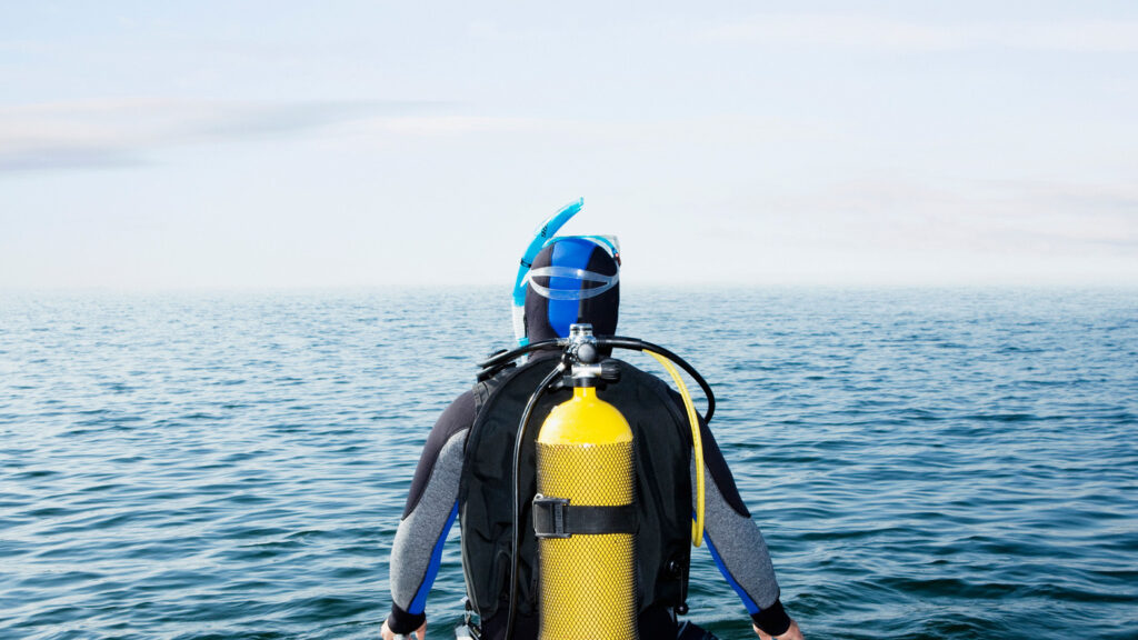 Diver sitting on end of pier
