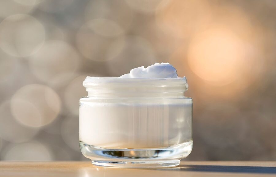 face cream in an open pot, blurred background