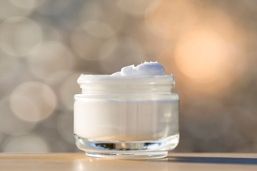 face cream in an open pot, blurred background